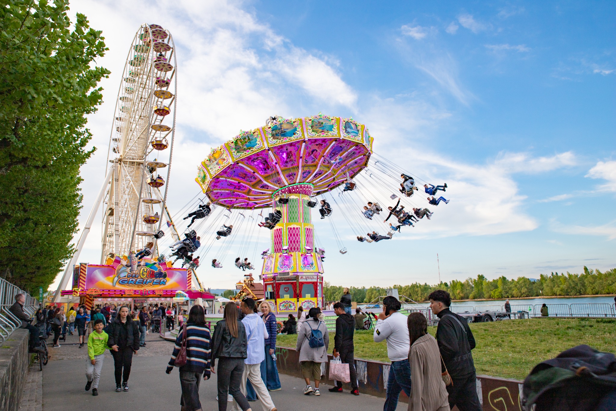 Jahrmarkt mit Riesenrad und Kettenkarussell am Rhein