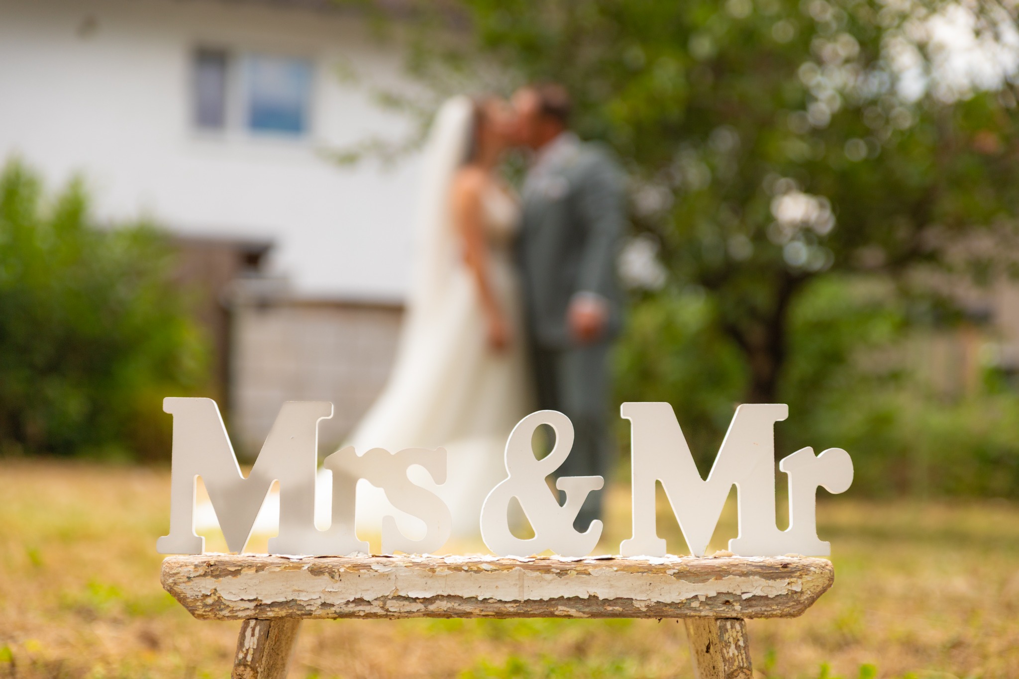 Dekoratives Mr & Mrs vor einem unscharfen Brautpaar