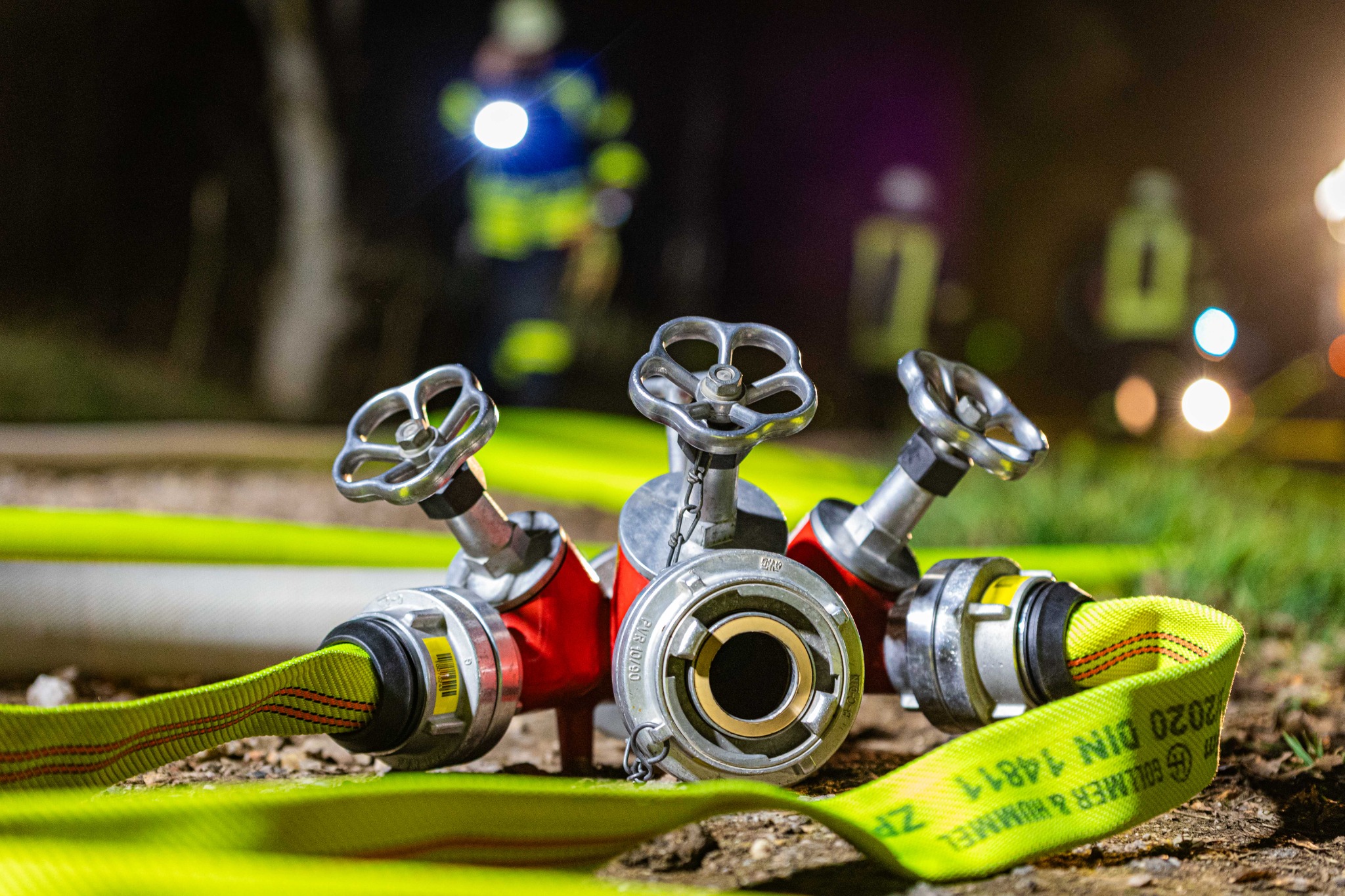 Feuerwehrarmatur und Schlauch bei einer Übung